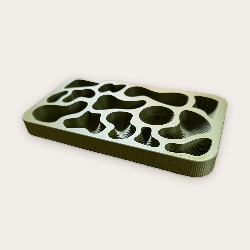 Low angle view of the Topography Tray terraced wells in pale sage window light