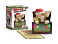 Santa Gizmo: a small furry Gremlins Mogwai in a red Santa hat peeking from a box strung with colorful lights, beside the green and red package
