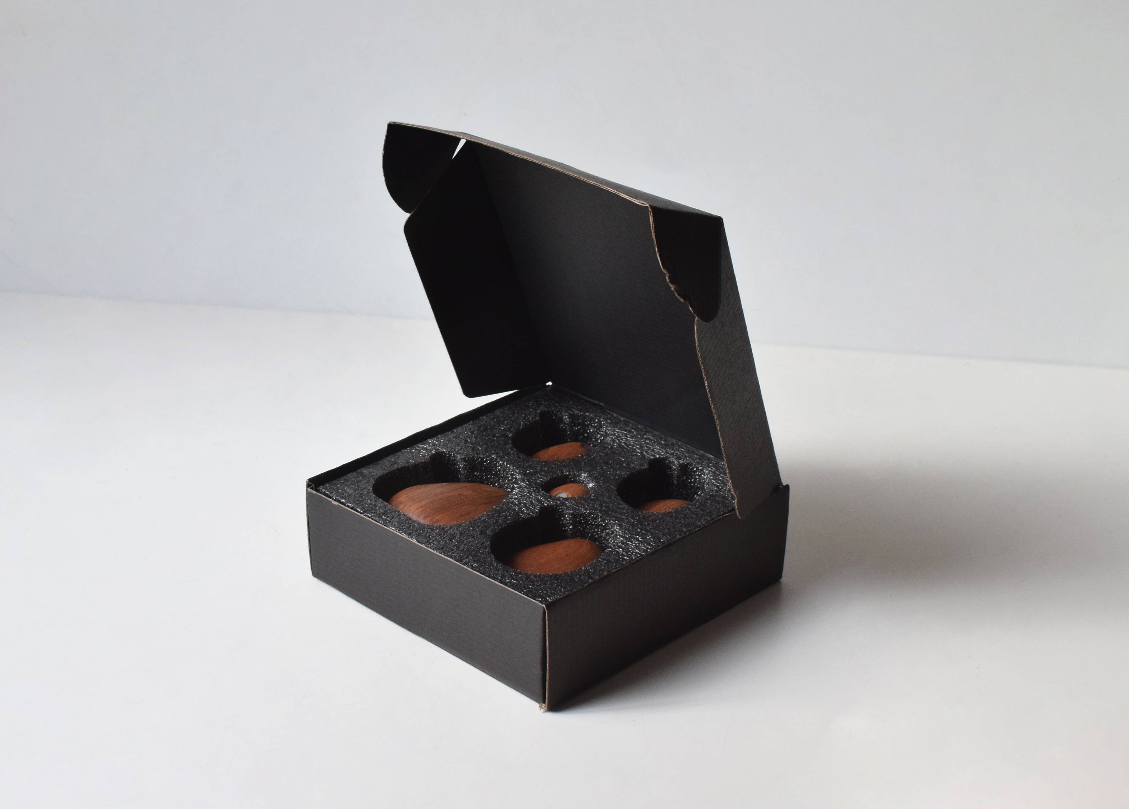 The five stones nested in the foam-lined black gift box they arrive in