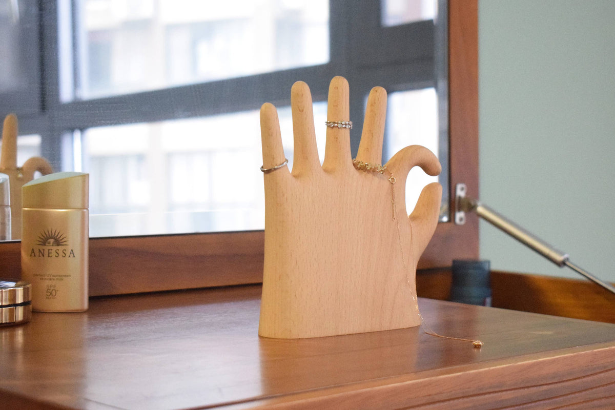 The beech OK hand holding rings on its fingers, on a wooden dresser by a city window