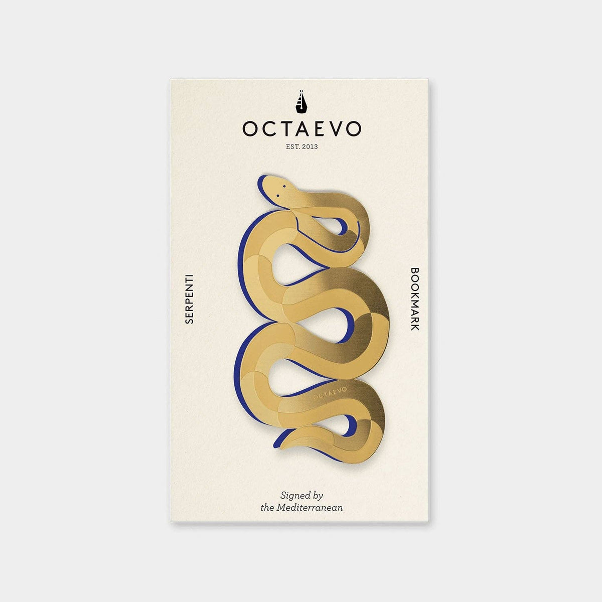 Serpenti brass bookmark by Octaevo, a die cut coiled snake in varnished brass on its postcard mount