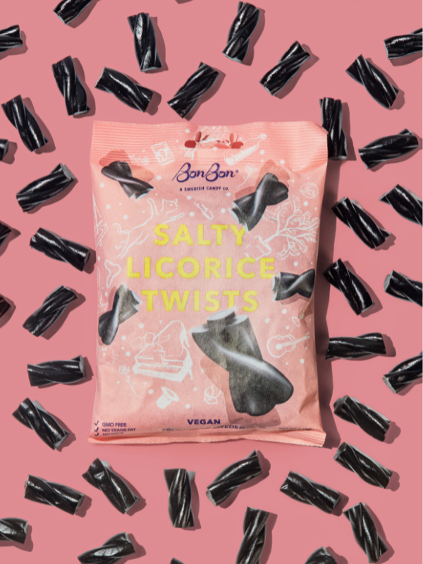 BonBon Salty Licorice Twists bag in pink on a pink ground scattered with black licorice twists