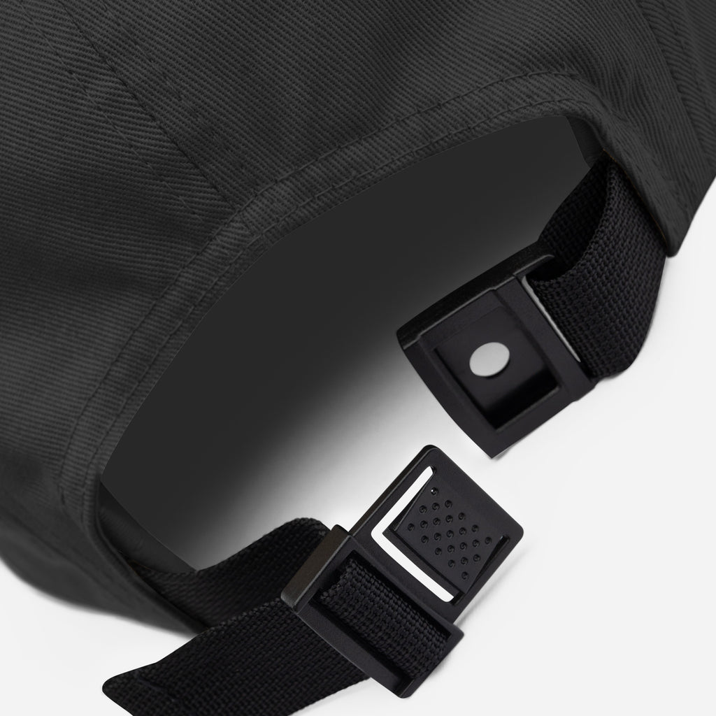 Detail of the cap's five panel construction and stitched seams in black cotton
