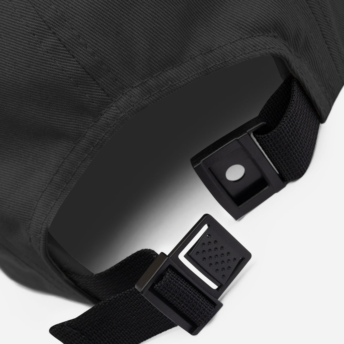 Detail of the cap's five panel construction and stitched seams in black cotton