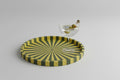 Pinwheel Tray on a pale ground with a coupe glass of olives resting on its rim