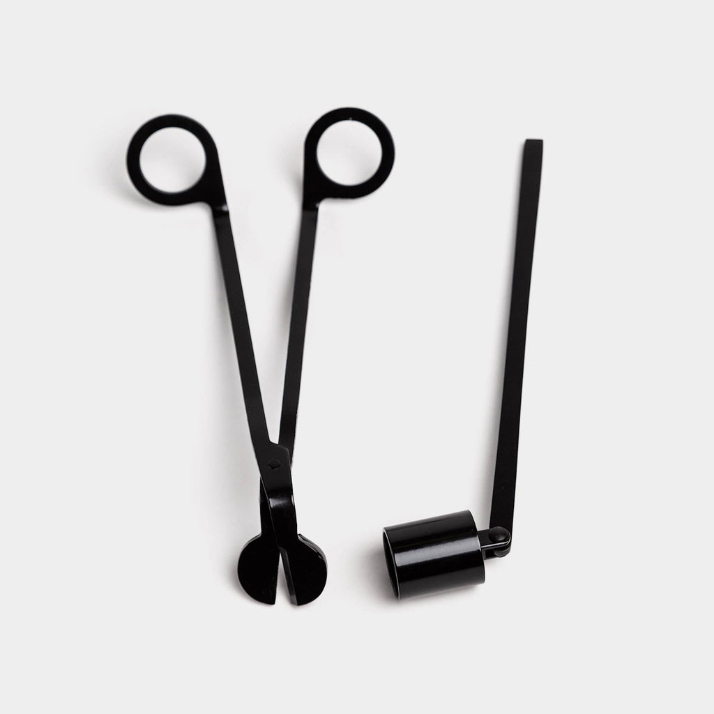 The black wick trimmer and bell snuffer side by side on a white ground