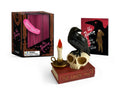 The Raven kit: a black raven perched on a skull above a stack of books with a red candle, beside its box and a small illustrated copy of the poem