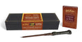 Harry Potter Light and Sound Wand Set: a dark wooden replica wand in front of its black and gold keepsake case, with the small red hardcover guidebook beside it