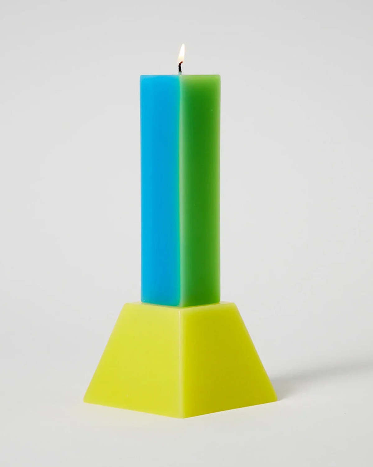 Happiness 1 pillar candle lit, a blue and green column on a yellow tapered base