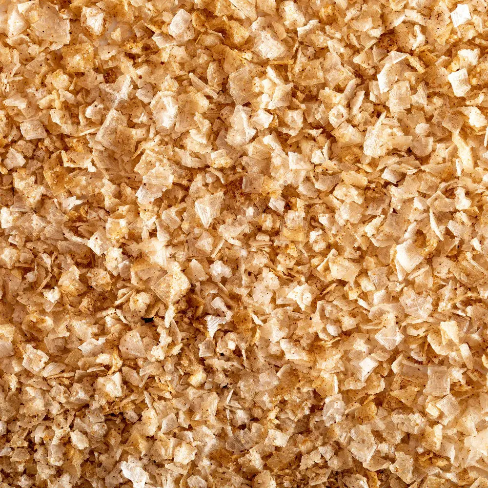 Close up of pale golden cherrywood smoked sea salt flakes