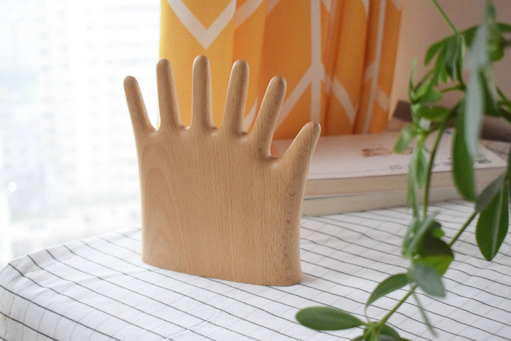 The six-fingered palm stand on a striped cloth by a window, with a trailing plant