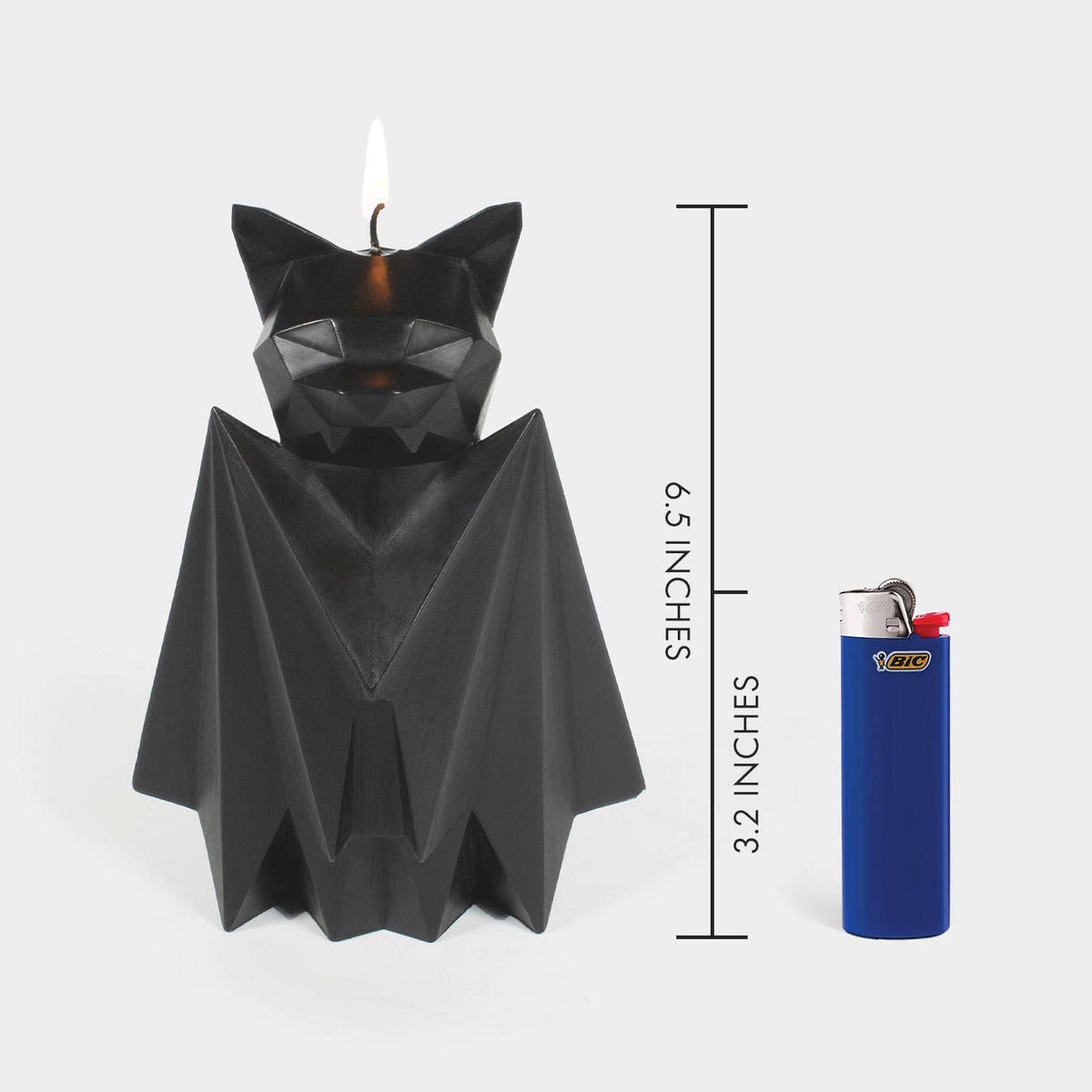Blaka bat candle next to a lighter for scale, marked 6.5 inches tall