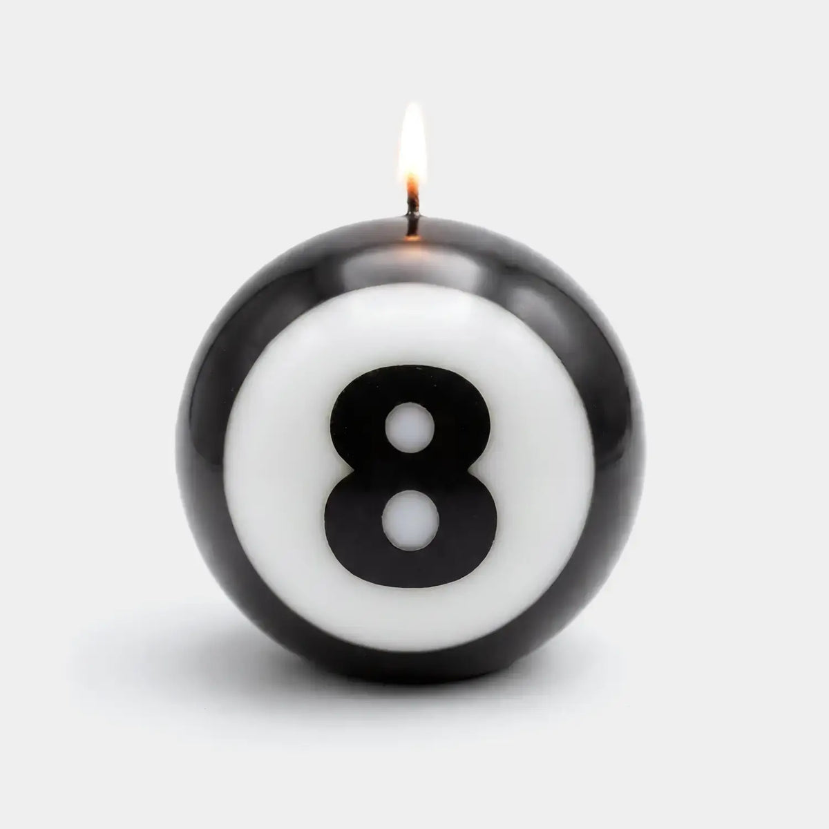 Classic 8-Ball candle lit on a white ground, the eight centered on the sphere