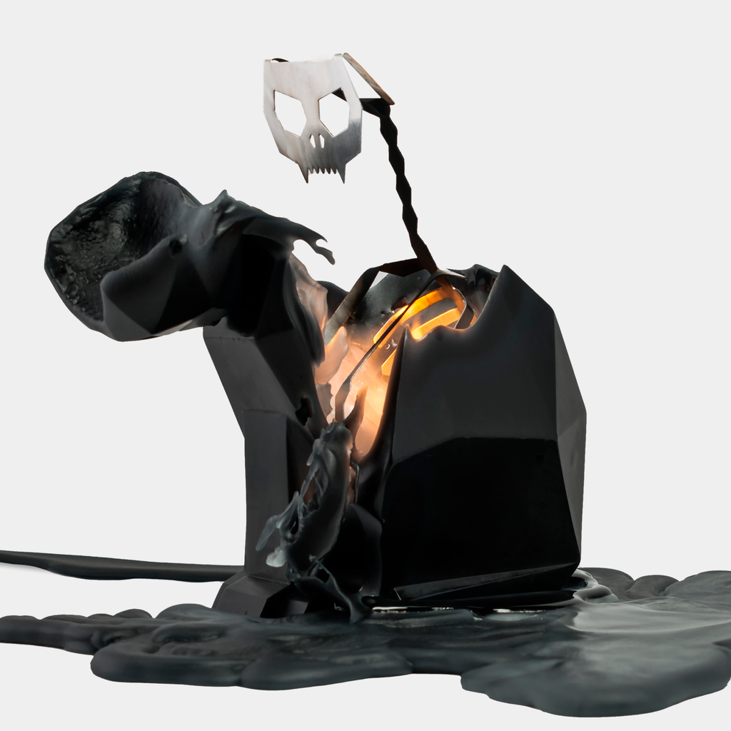 Kisa candle half burned, wax pooled on a plate with the metal skull and spine exposed