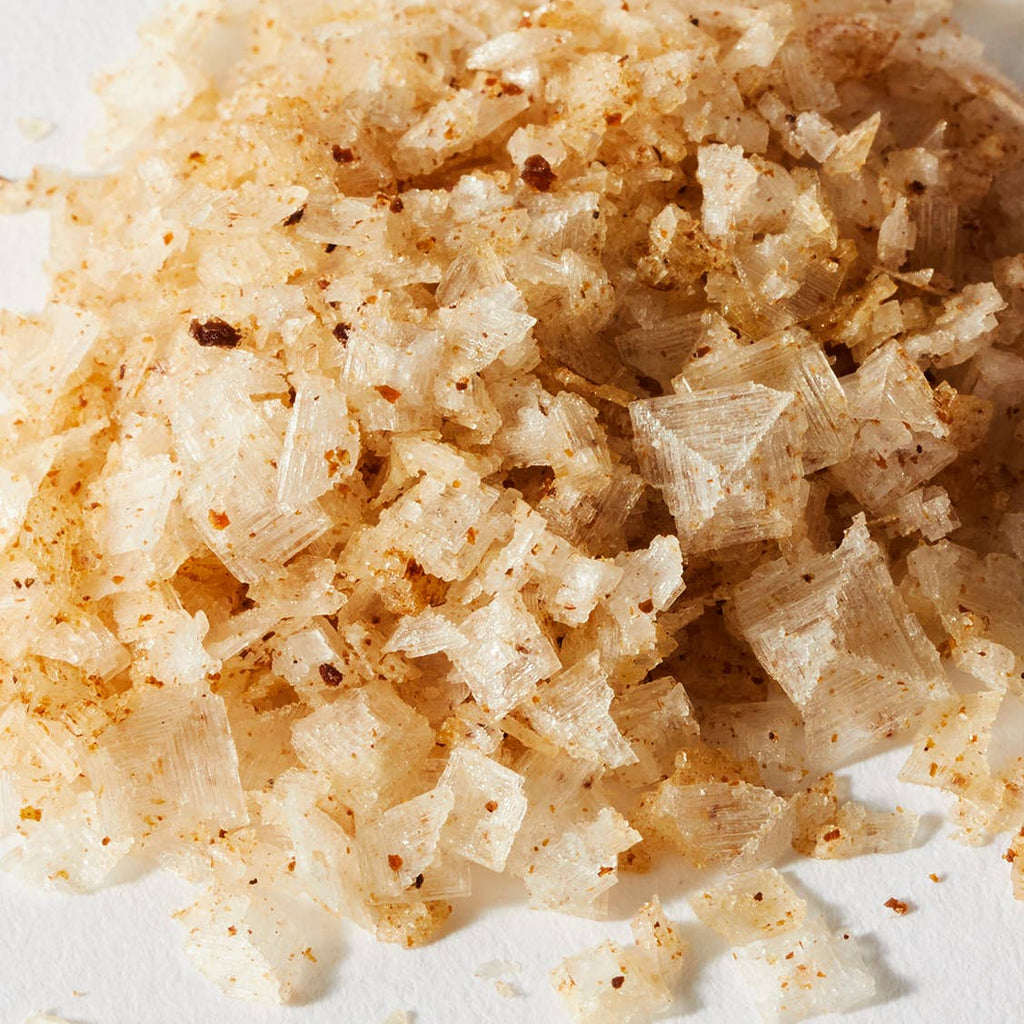 Close up of large white sea salt flakes speckled with brown ground truffle