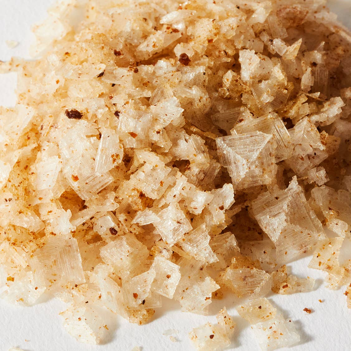 Close up of large white sea salt flakes speckled with brown ground truffle