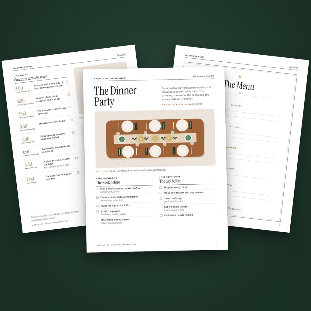 Three pages of The Dinner Party hosting kit fanned on moss green, the first page showing a wooden table from above set with six plates and three candles