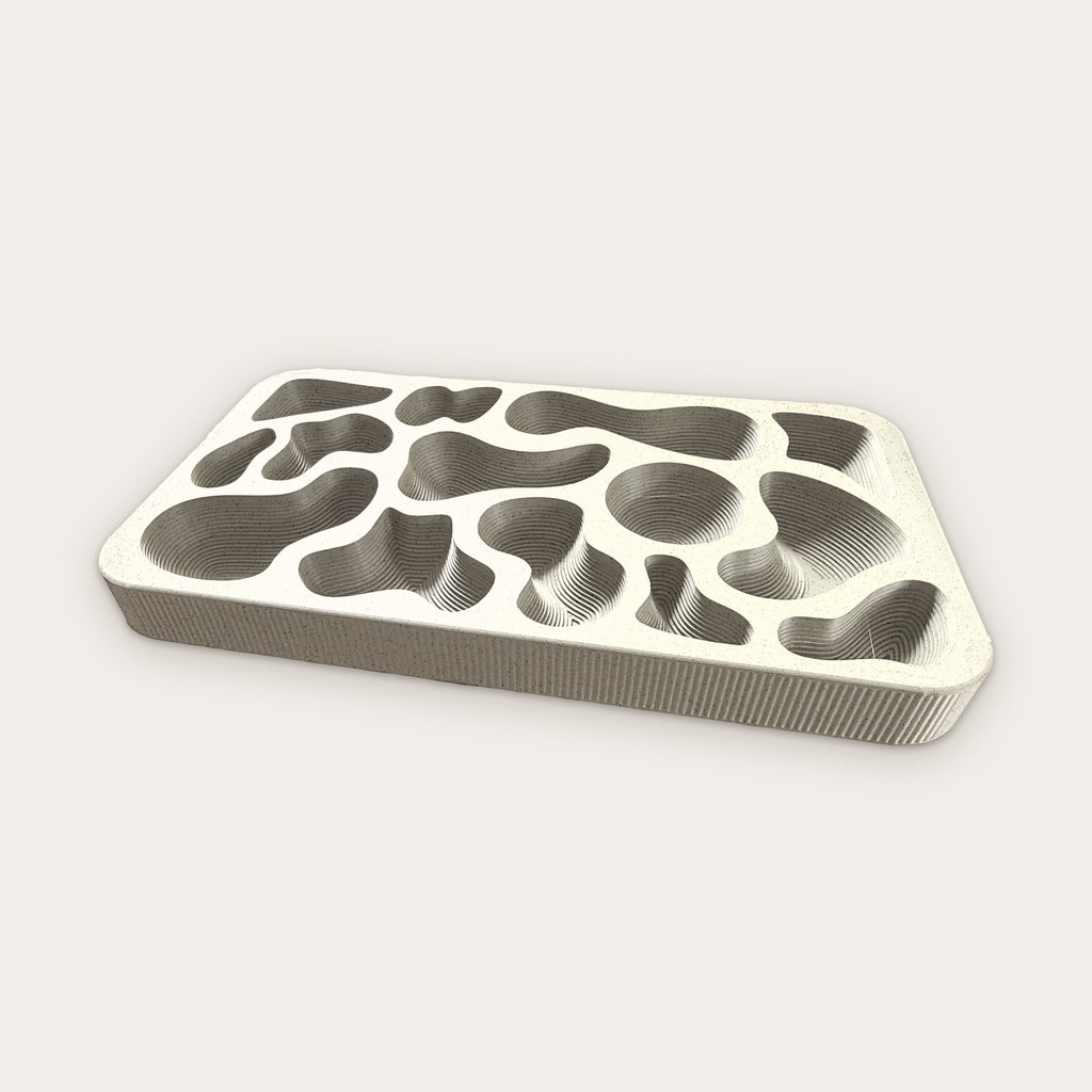 Topography Tray in Limestone, a pale speckled stone color with terraced wells and fluted sides