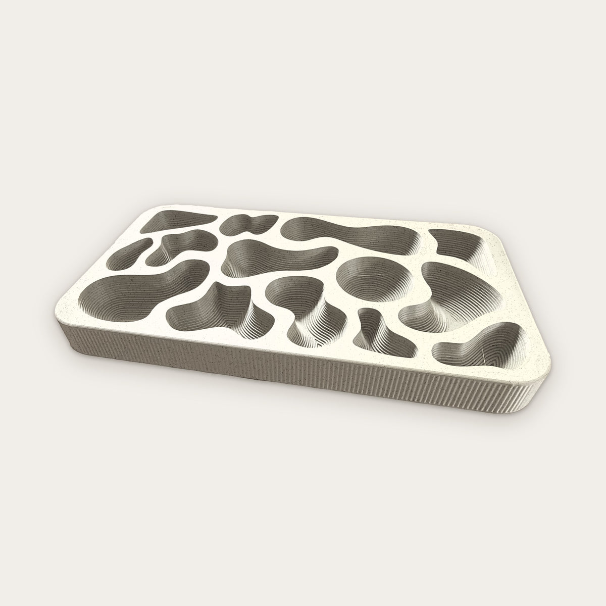 Topography Tray in Limestone, a pale speckled stone color with terraced wells and fluted sides
