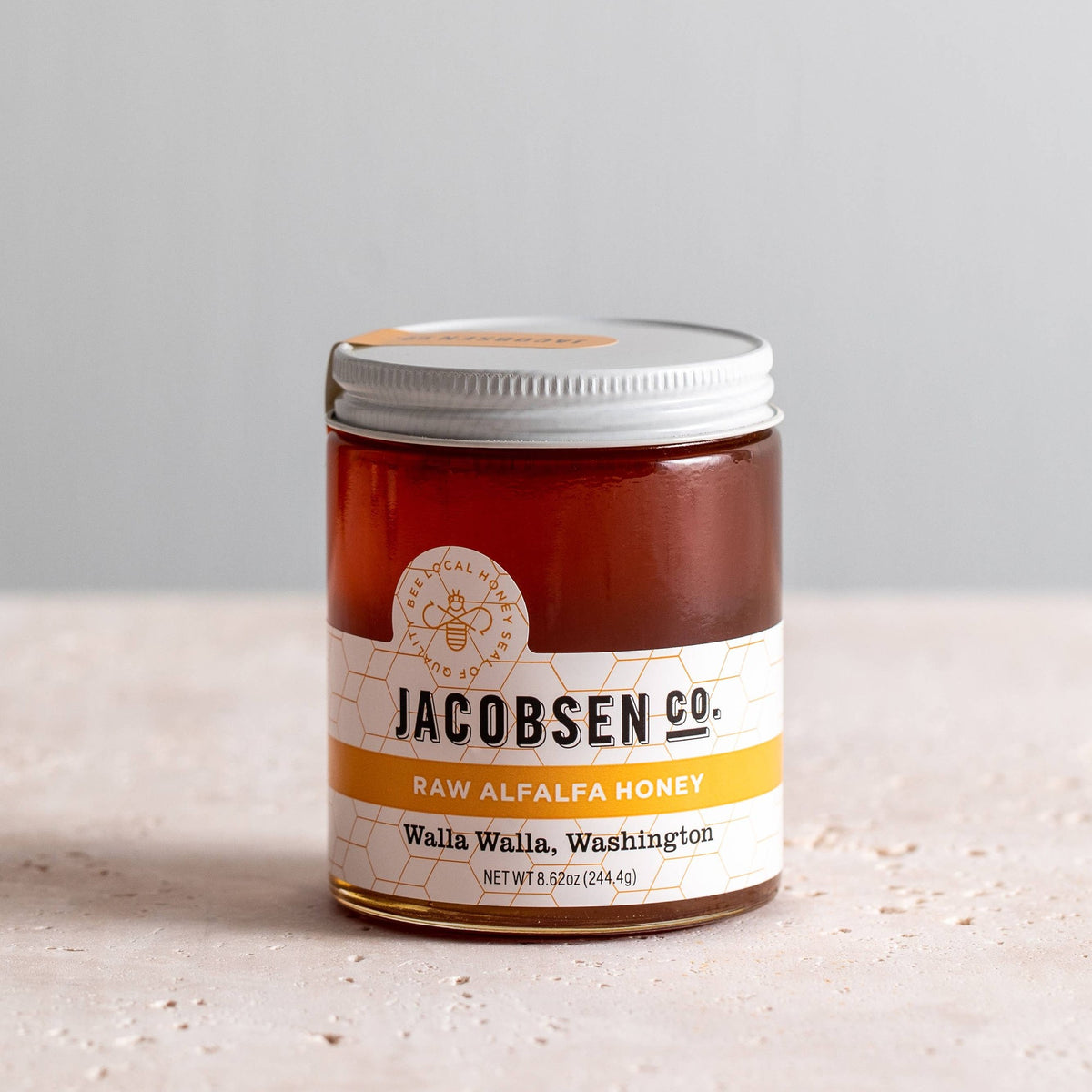 Jar of Jacobsen Co. Raw Alfalfa Honey from Walla Walla, Washington, amber honey under a white and yellow label