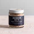 Jar of Jacobsen White Truffle Salt, 2.46 oz, with a navy label and white lid on a pale stone table