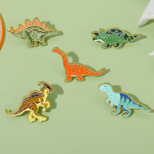 Divertidos y coloridos alfileres de dinosaurios de metal.